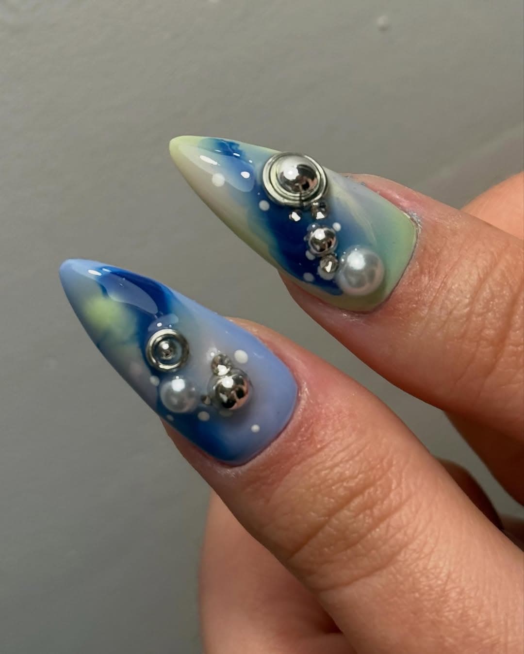 Gros plan nail art Galaxy : nuages bleus, perles et billes chrome, Lyon