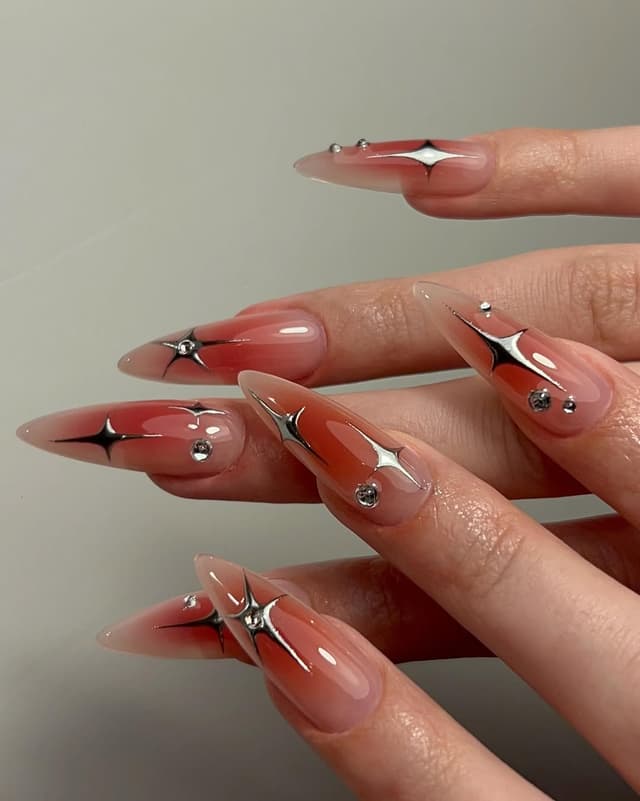 Aura rouge cerise et étoiles chrome sur base milky, pose Gel-X stiletto, nail art Lyon 1er